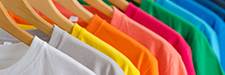 Close up of Colorful t-shirts on hangers, apparel background